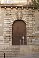 Arc de mig punt amb extradós en escala emmarcant la porta principal del Palau de Justícia, de Manresa, de l'any 1671.