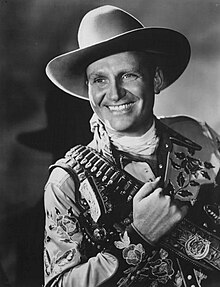 Black and white pic of Gene Autry, smiling and dressed in fancy Mexican garb and a bandoleer