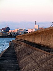 Photo of seawall, with building in background