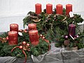 Adventslysestake (øverst), adventskrans (til venstre) og et adventslys (til høyre) med tykke lys.