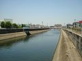 第二寝屋川新楠根橋より下流を望む。見える橋は丸屋大橋。左岸に見えるのは川俣水みらいセンターとの合流口。