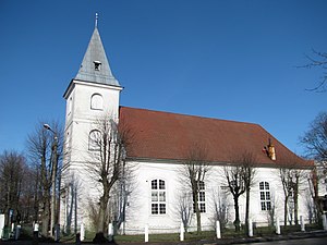 Weiße Kirche mit Leuchtfeuer im Turmdach