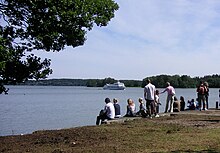 Photo de gens assis au bord d'un cours d'eau