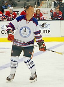 Photographie de Paul Coffey en maillot blanc lors d'un match de gala.