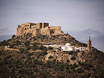 Fort of Santa Cruz on a hill in the distance, with a mosque slightly lower in elevation