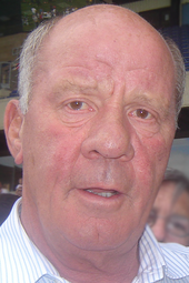 Head of a red-faced bald middle-aged white man.