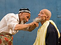 Uyghur Barber in Kashgar. Traditionally Uyghur men shave their heads and wear a hat called doppa.