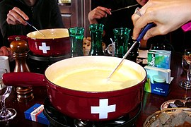 Caquelon de fondue au fromage sur son réchaud.