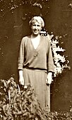 Sepia portrait of a woman standing at a window; lots of light spots, but fewer than when I found it.