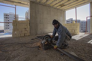 عکس از یک آهنگر ساختمانی در حال کار با ماشین سنگ جت در منطقه پردیسان قم