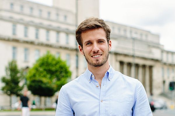 A Masters student stood in front of the Parkinson Building