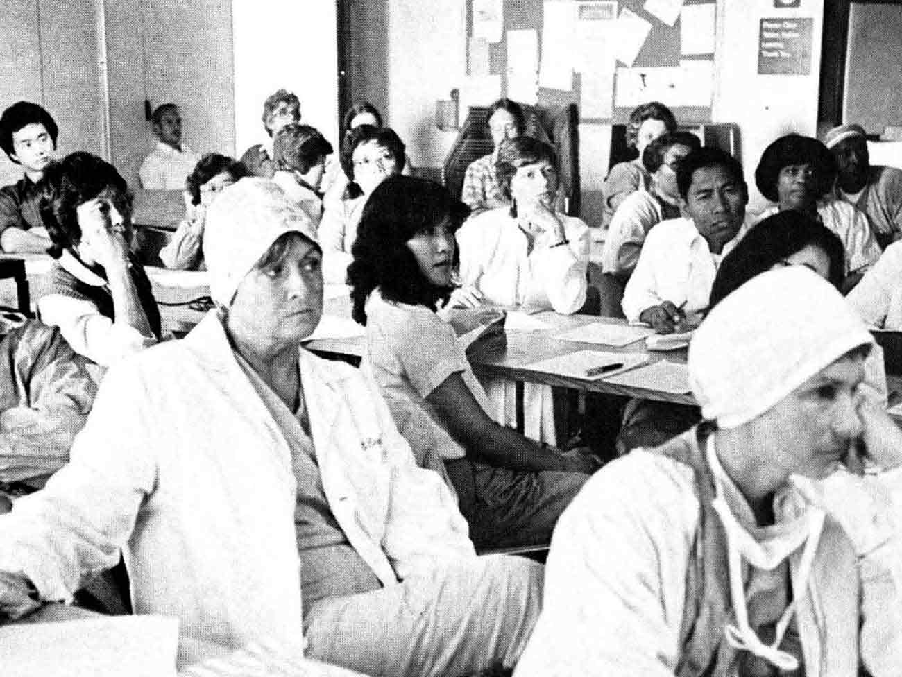 people seated inside a classroom facing the front of the room