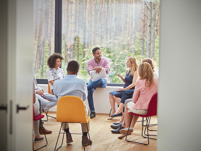 A group of people sitting in a circle talking