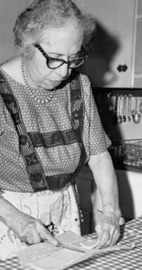 Fabiola cutting an object with a knife.