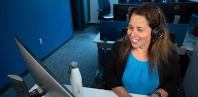 Administrative Services Center staff member working with a customer at a computer.