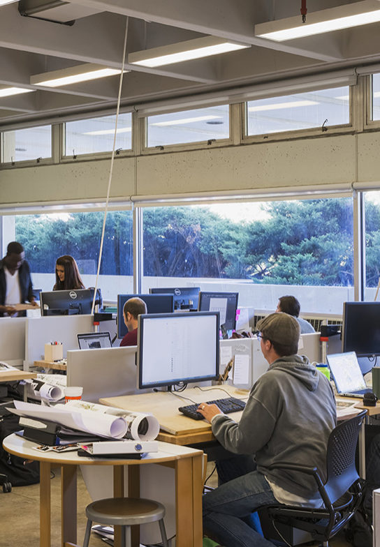 Students working at their desks in open studio space.