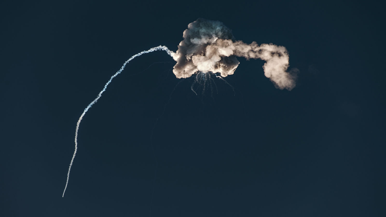 a jet is flying through the air with smoke coming out of it.