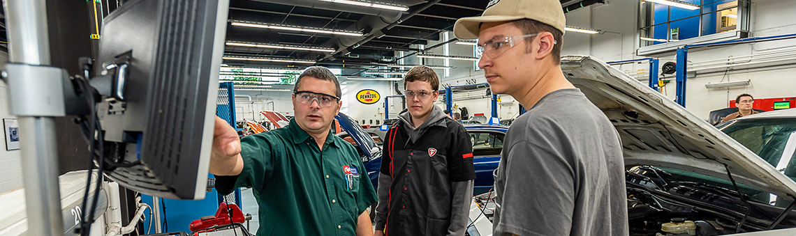 teacher and students in automotive garage