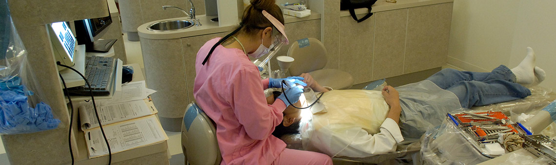 Hygienist working on patient in dental chair