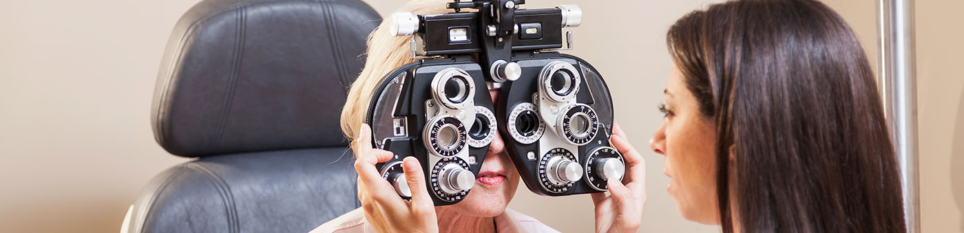 assistant adjusting eye care equipment for patient