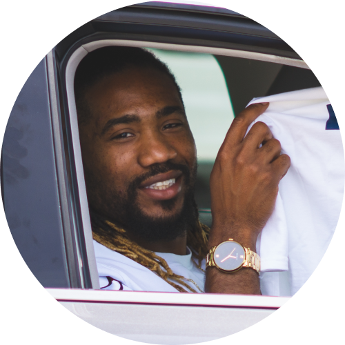 A photo of a male Uber driver holding up a Solo-branded T-Shirt