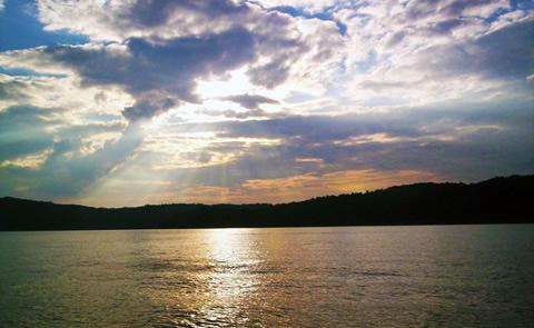 sun and clouds over lake