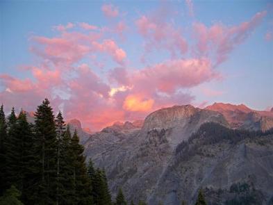 Sierra Nevada Wilderness Mountains with conifers and clouds at sunset.