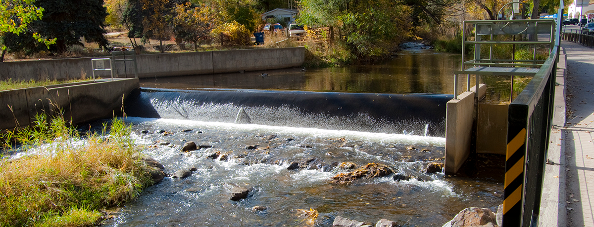 Creek flowing over ditch diversion infrastructure