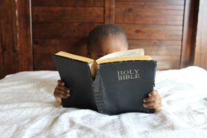 Bible verses about faith - child reading the bible