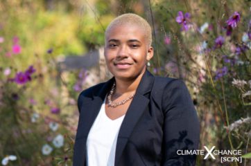 Interviewee, McKenna Dunbar standing in front of a field of wildflowers