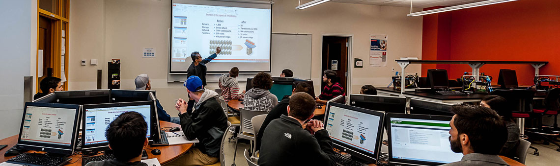 students in a computer lab listening to the teacher