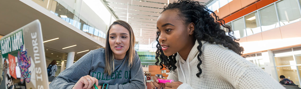 two students working together on a laptop