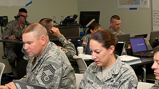 people in military unforms working on computers