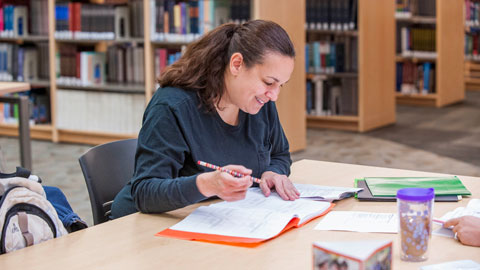 student in library working on classwork