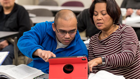 Two students using an ipad in a classroom