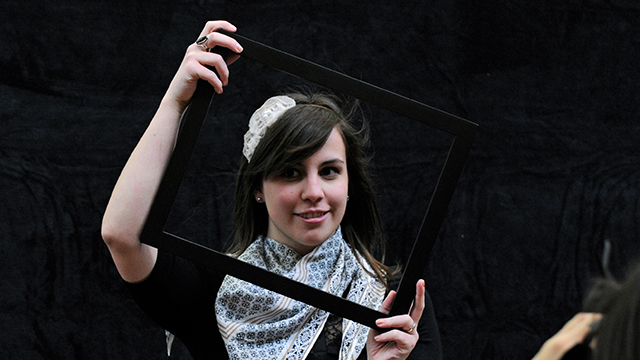 Theater student looks through a stage prop