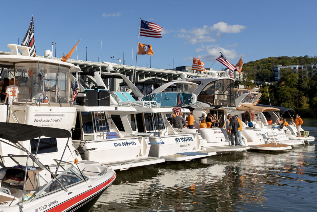 boats gather on the Tennessee river to tailgate during a football game during the fall