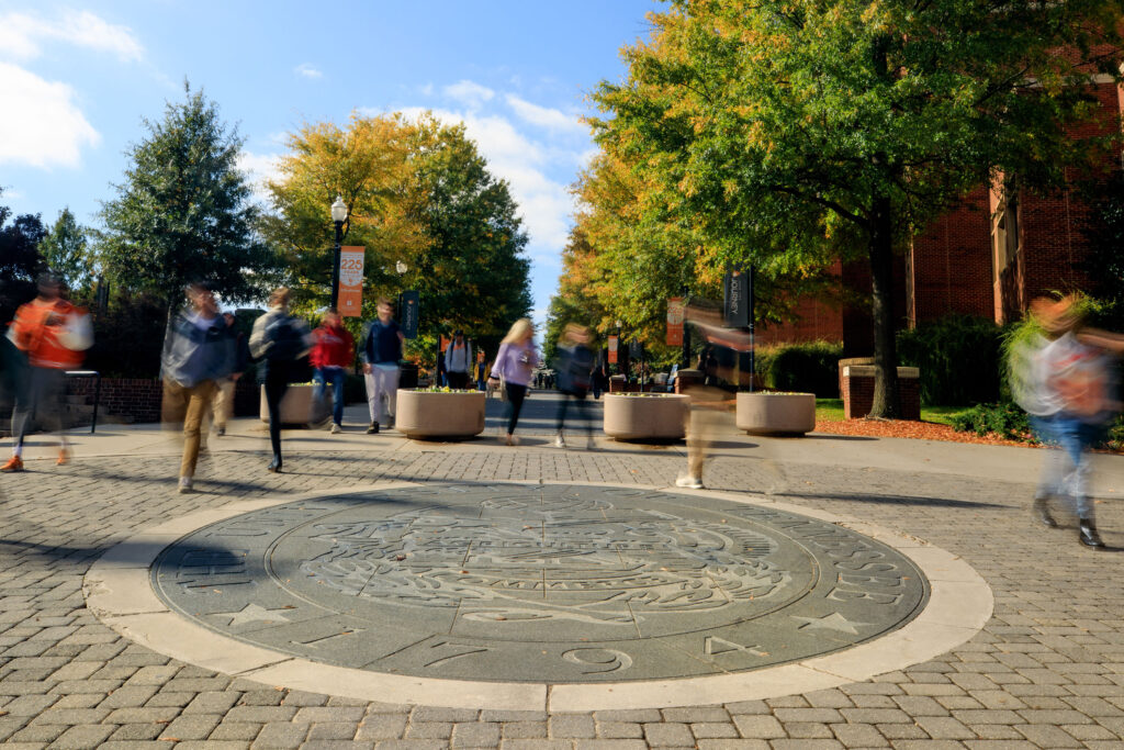 a time-lapse photo showing students avoiding walking on the seal