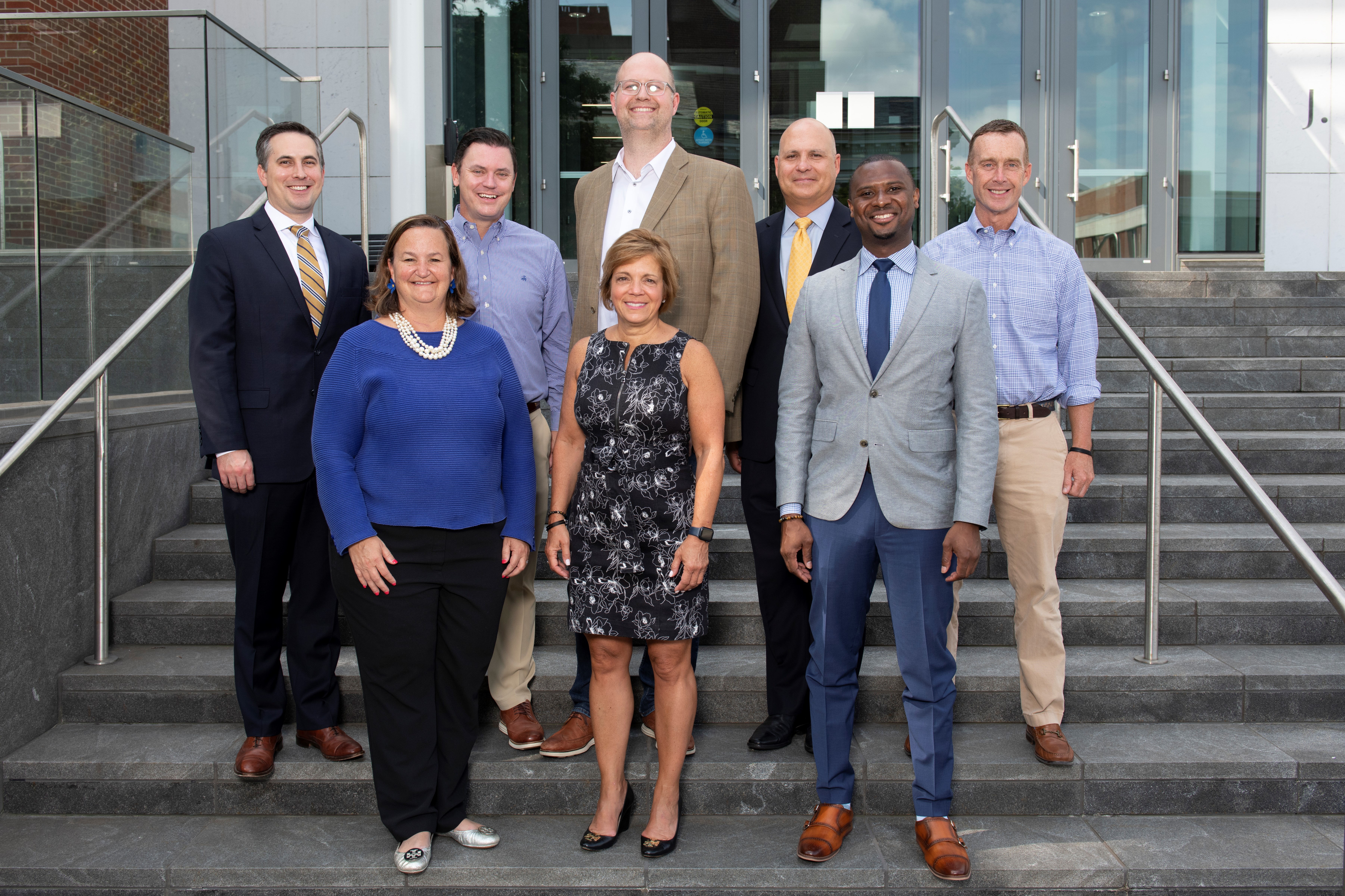 a photograph of the MHA 22-23 Board of Advisors standing on steps. Drew Gray, Rob Edwards, Ammon Fillmore, John Phillips, Scott Watkins Kathleen Love, Janine Nowatzky, Grayling Yarbrough Not Pictured: Mark Bowman, Amanda Sokan