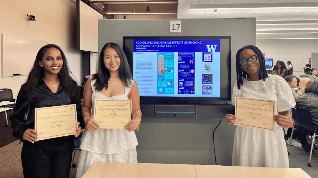 Haben Berhane, July Paw and Madeleine Loua (LIN scholars) stand next to their poster.