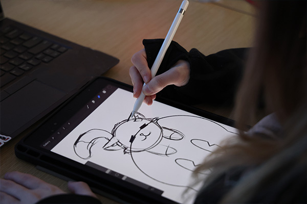 Production animation student drawing a round chubby cat on a tablet.