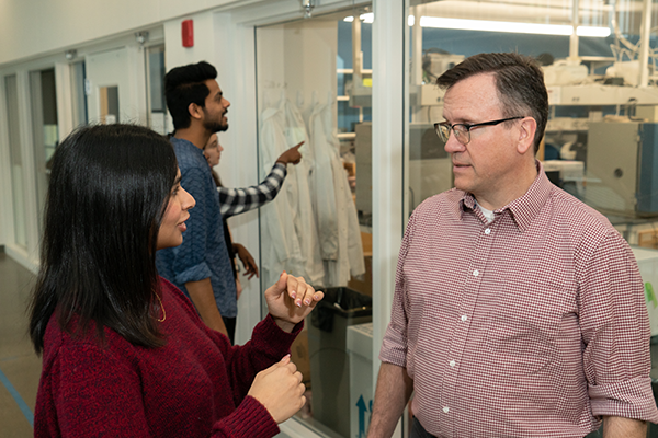 A woman and man talking outside of a lab