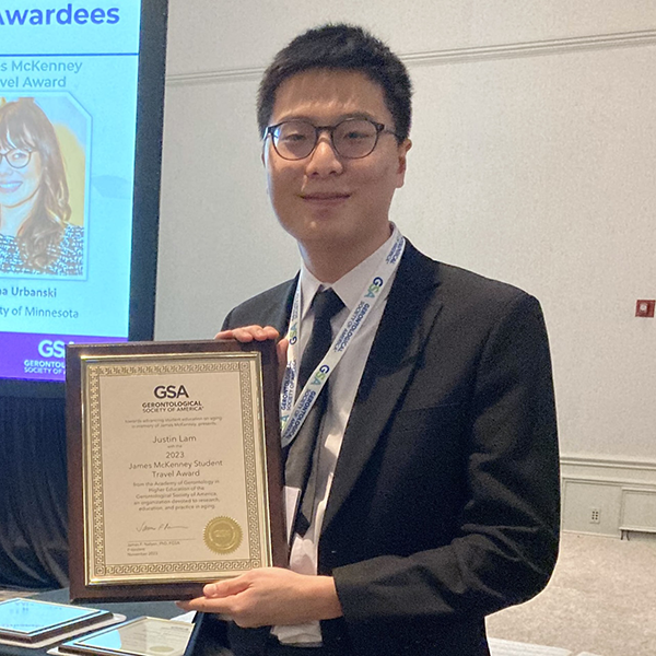 A male student holding an award