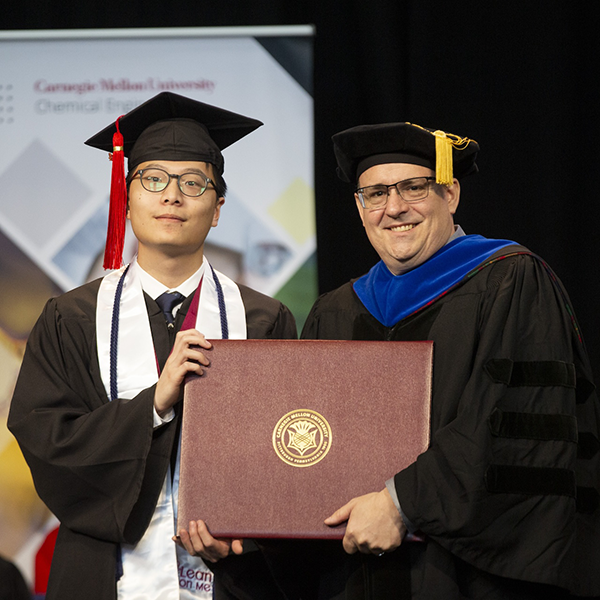 Student at graduation with a professor