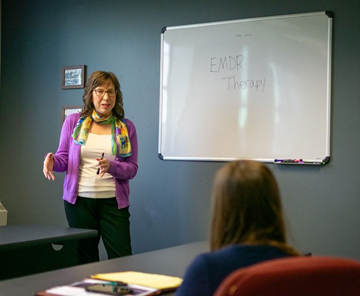 Tracey Marchese standing in front of a classroom with a woman sitting at a desk