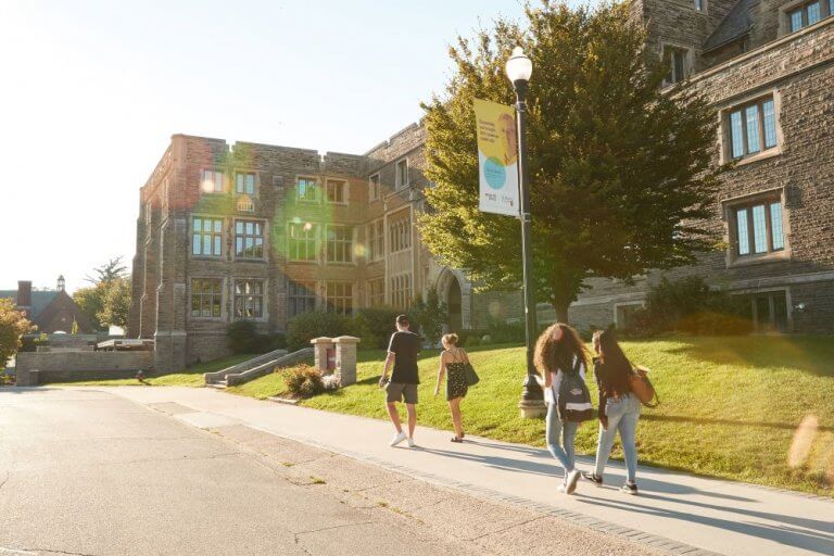 Students walking across campus in the summer