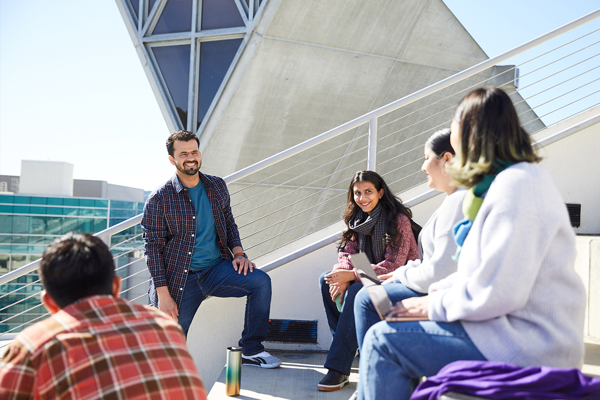 Five SF State students smiling and having a discussion