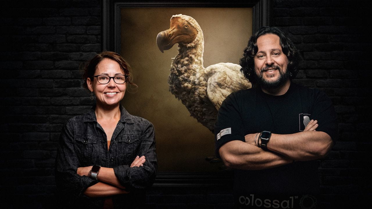 Beth Shaprio and Ben Lamm from Colossal Biosciences stand in front of a large replica of a dodo bird.