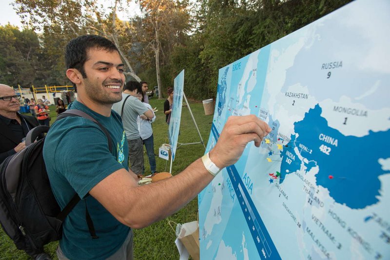 Student placing a pin on a map to indicate home country at the Welcome BBQ