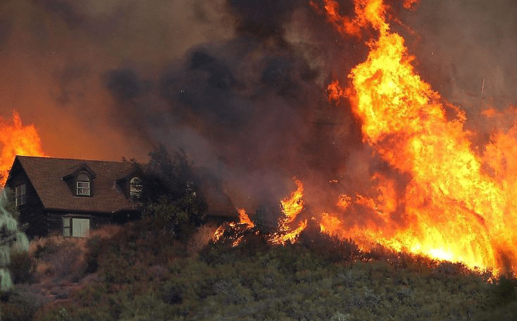 Wildfire burns near a home in California